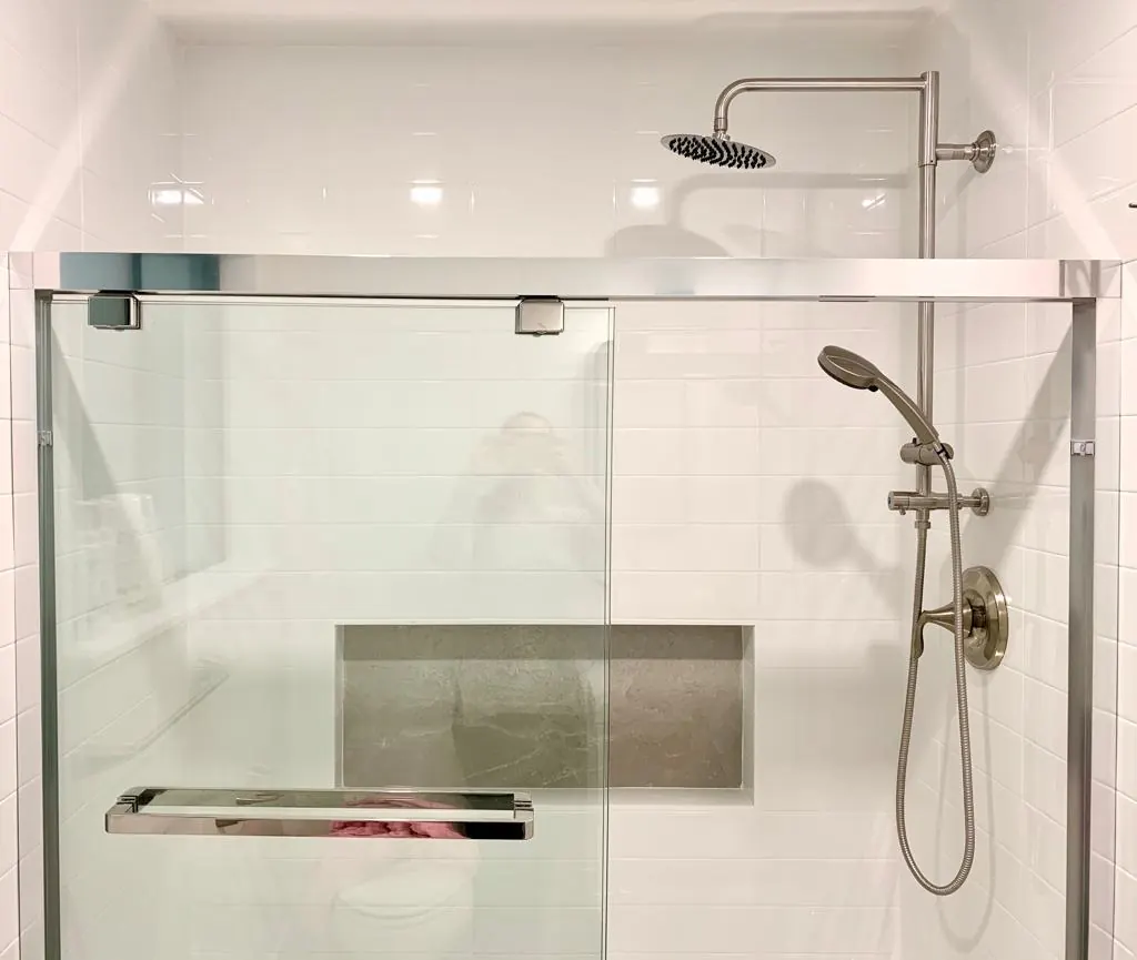 A sliding glass shower enclosure, white wall tile and a wide recessed niche. Redmond, WA