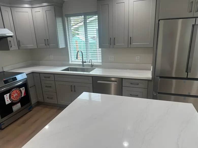 Gray cabinet fronts, light counters and a sink beneath the window. Bothell, WA