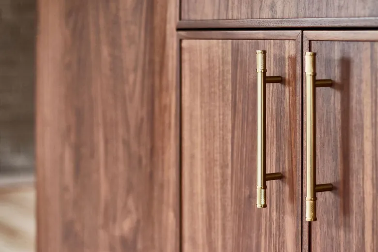 A close view of walnut grain and long brass cabinet pulls. Bellevue, WA